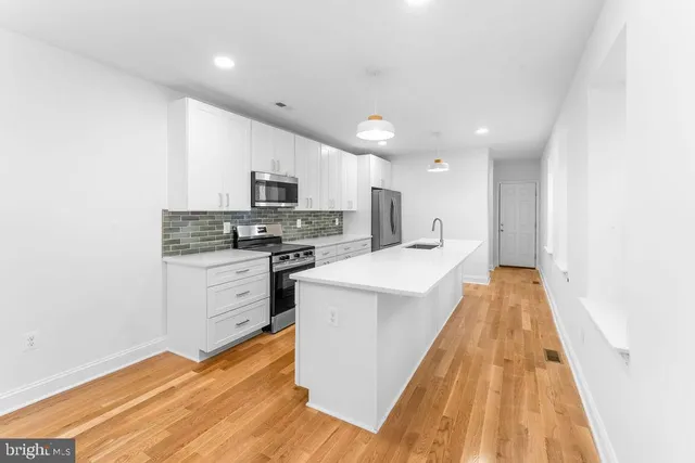a kitchen with a sink a stove top oven and white kitchen