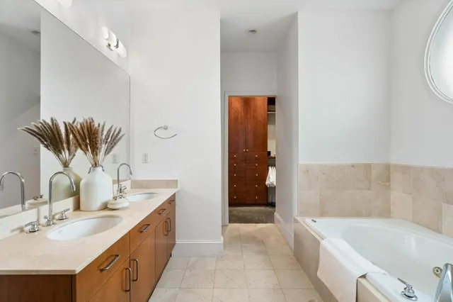 a bathroom with a tub sink and mirror