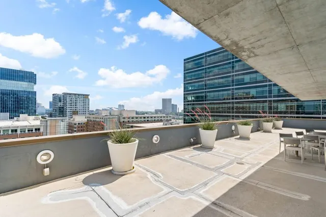 a view of roof deck with chairs and barbeque