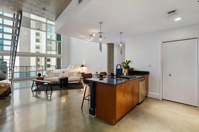 a living room with furniture a chandelier and a dining table