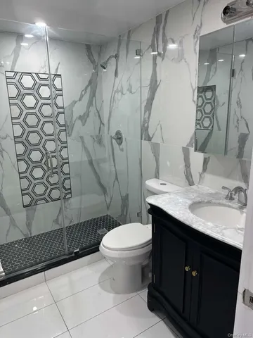 a bathroom with a granite countertop sink toilet and shower
