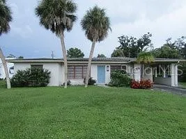 front view of a house with a yard and potted plants