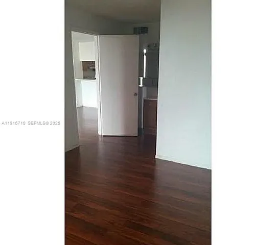 a view of a room with wooden floor and chandelier