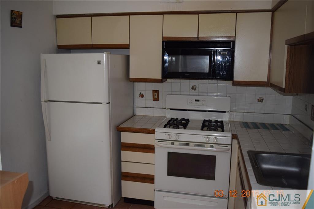205 Commons Way, Unit 5 East Brunswick, NJ 08816 - Photo 2 of 10 a kitchen with a stove and a microwave
