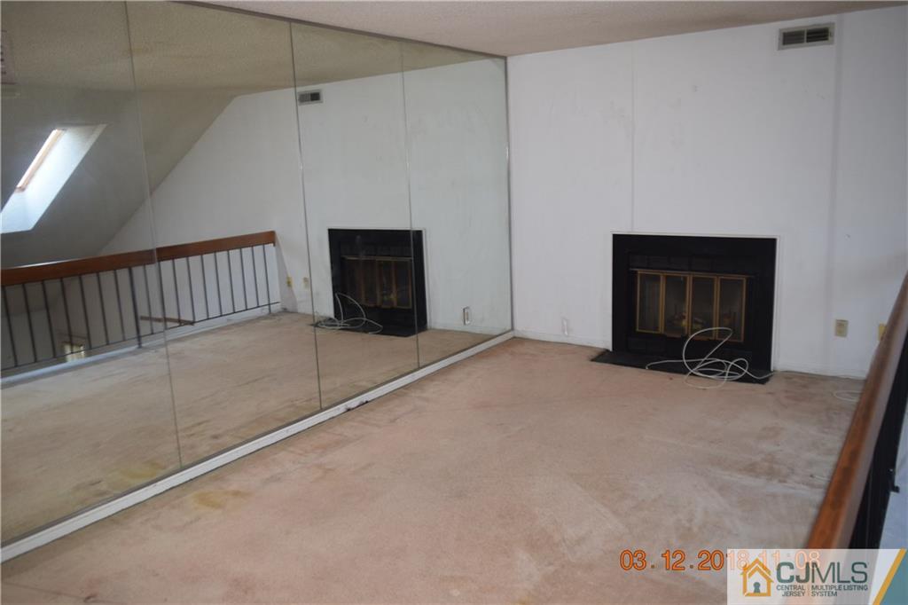 205 Commons Way, Unit 5 East Brunswick, NJ 08816 - Photo 5 of 10 a view of an empty room with a fireplace