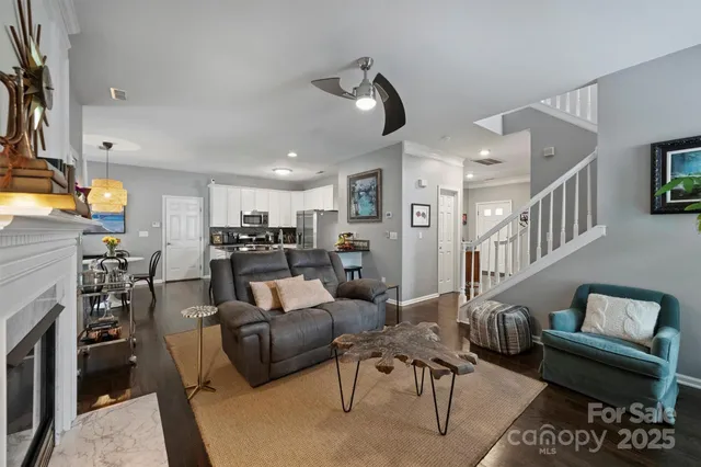 a living room with furniture kitchen view and a flat screen tv