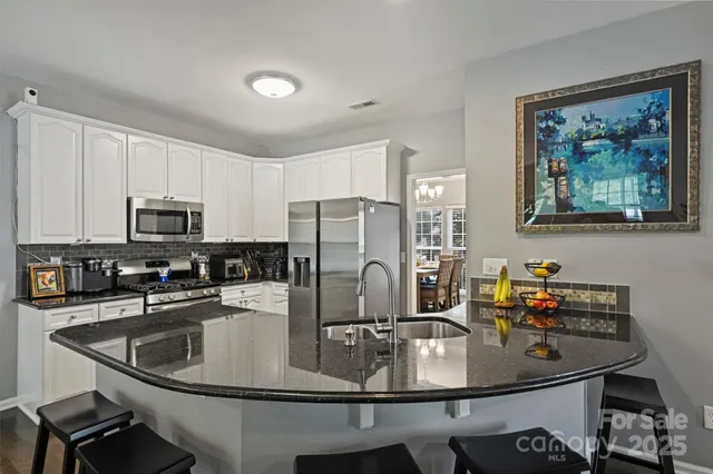 a kitchen with kitchen island a sink stove and refrigerator