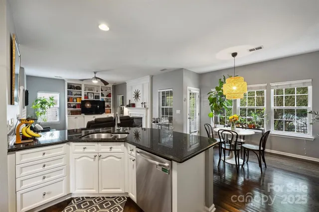 a kitchen with a dining table chairs stainless steel appliances and cabinets