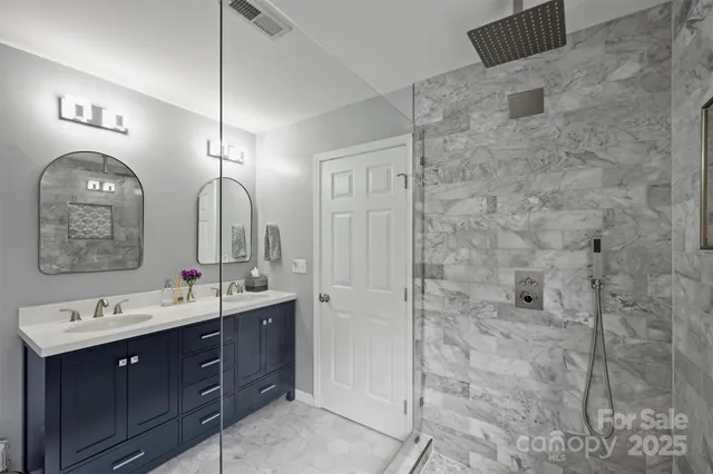 a bathroom with a double vanity sink mirror and shower