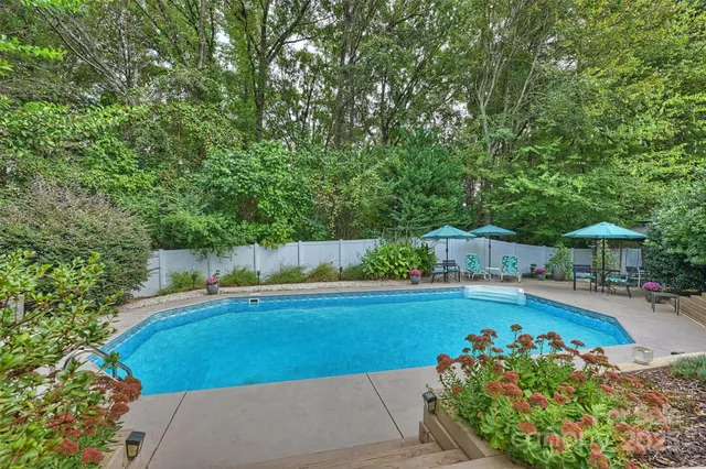 a view of a swimming pool with a patio and a yard