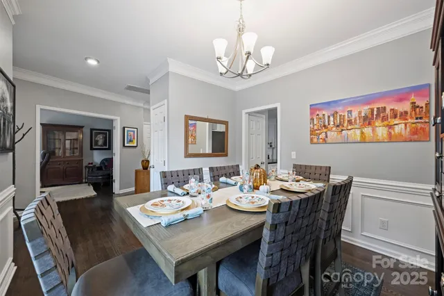 a view of a dining room with furniture a chandelier and wooden floor