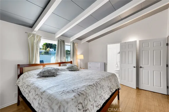 a bedroom with a bed and wooden floor