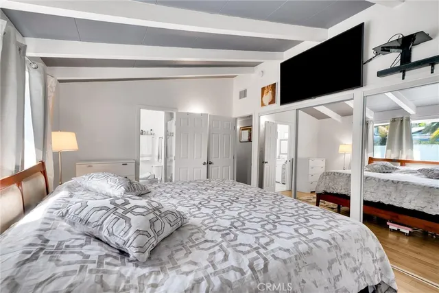 a bedroom with a bed and a flat tv screen on wall