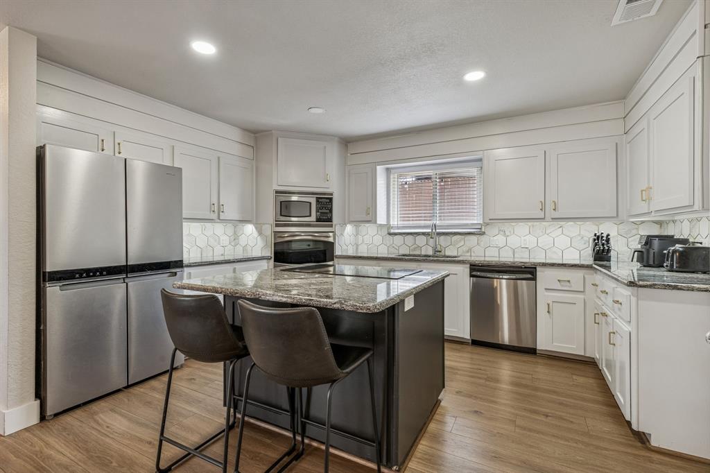 4512 Ranch View Road Fort Worth, TX 76109 - Photo 13 of 40 a kitchen with stainless steel appliances granite countertop a stove a sink a refrigerator a microwave and cabinets