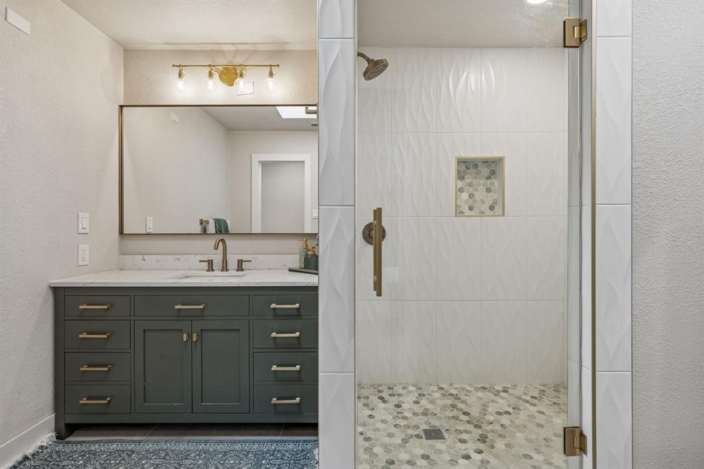4512 Ranch View Road Fort Worth, TX 76109 - Photo 24 of 40 a bathroom with a granite countertop sink a mirror and shower