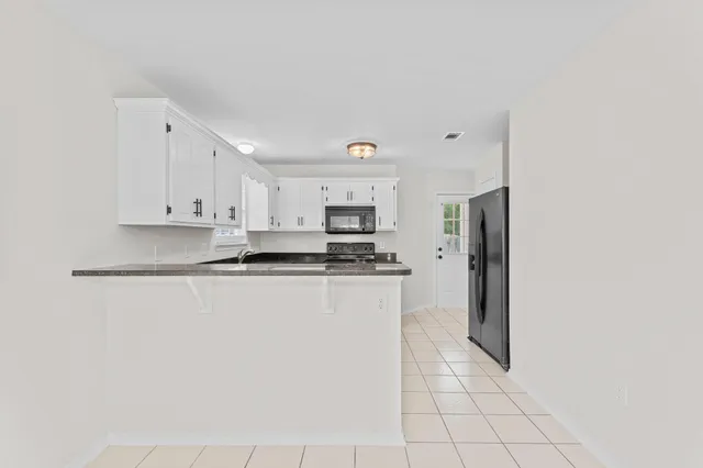a kitchen with granite countertop cabinets stainless steel appliances a sink and a window