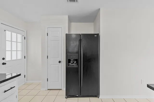 a kitchen with granite countertop white cabinets appliances and a window