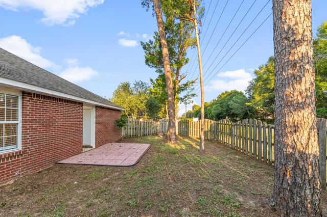 a view of a small yard in front of a house with a large tree