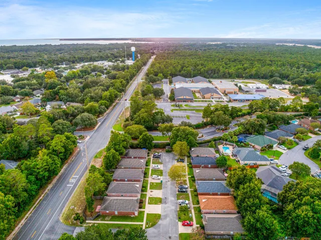 an aerial view of residential houses with outdoor space and trees