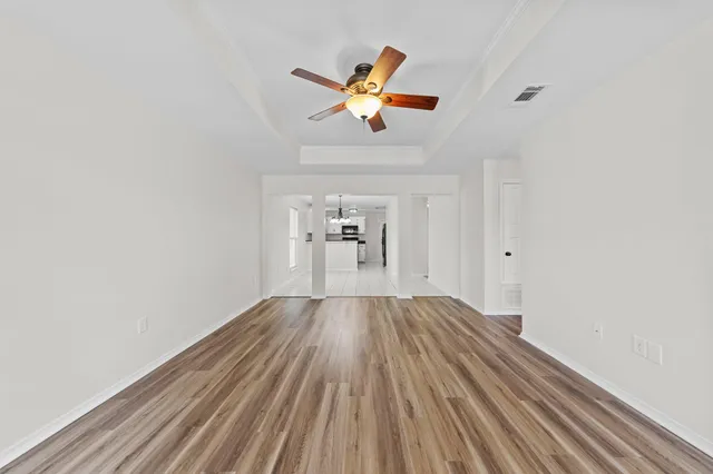 a view of empty room with wooden floor