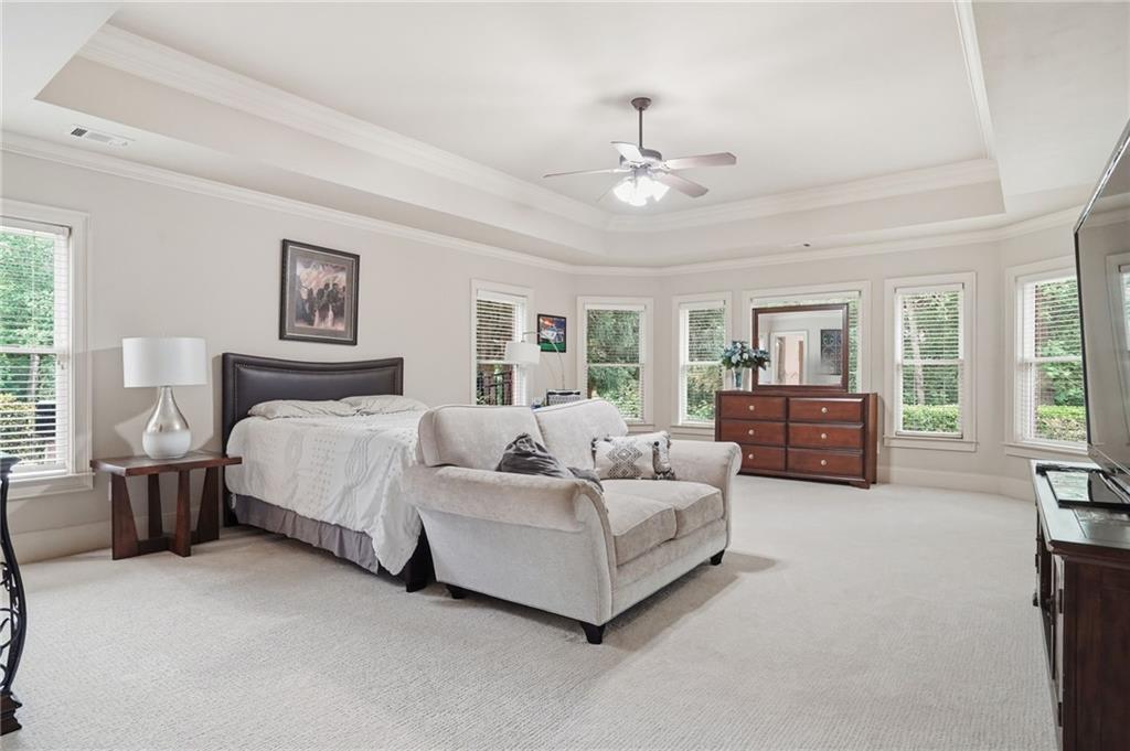 8340 Colonial Place Duluth, GA 30097 - Photo 50 of 74 a spacious bedroom with a large bed and a chandelier