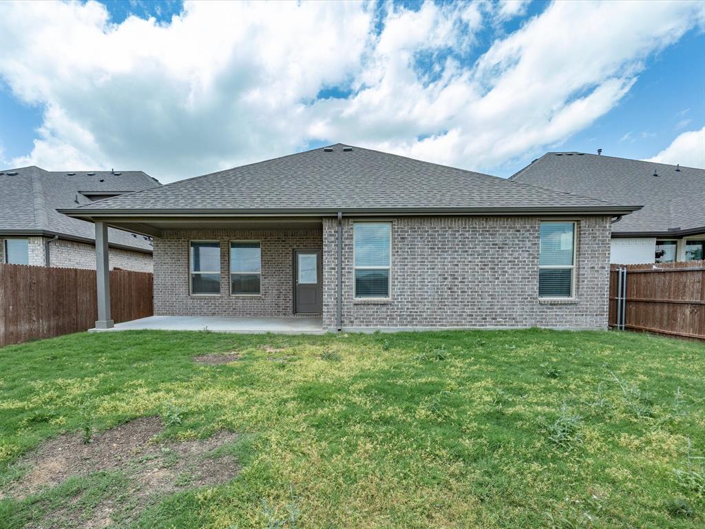 1121 Knightsbridge Road Argyle, TX 76226 - Photo 35 of 39 Brick exterior featuring a covered patio, multiple windows, and a fenced backyard