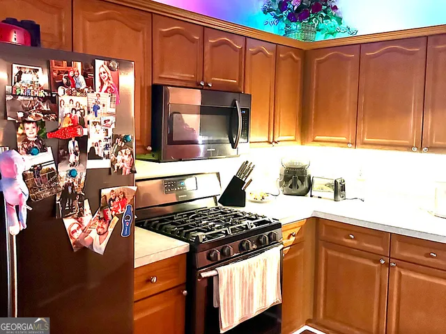 a kitchen with stainless steel appliances granite countertop a stove and cabinets