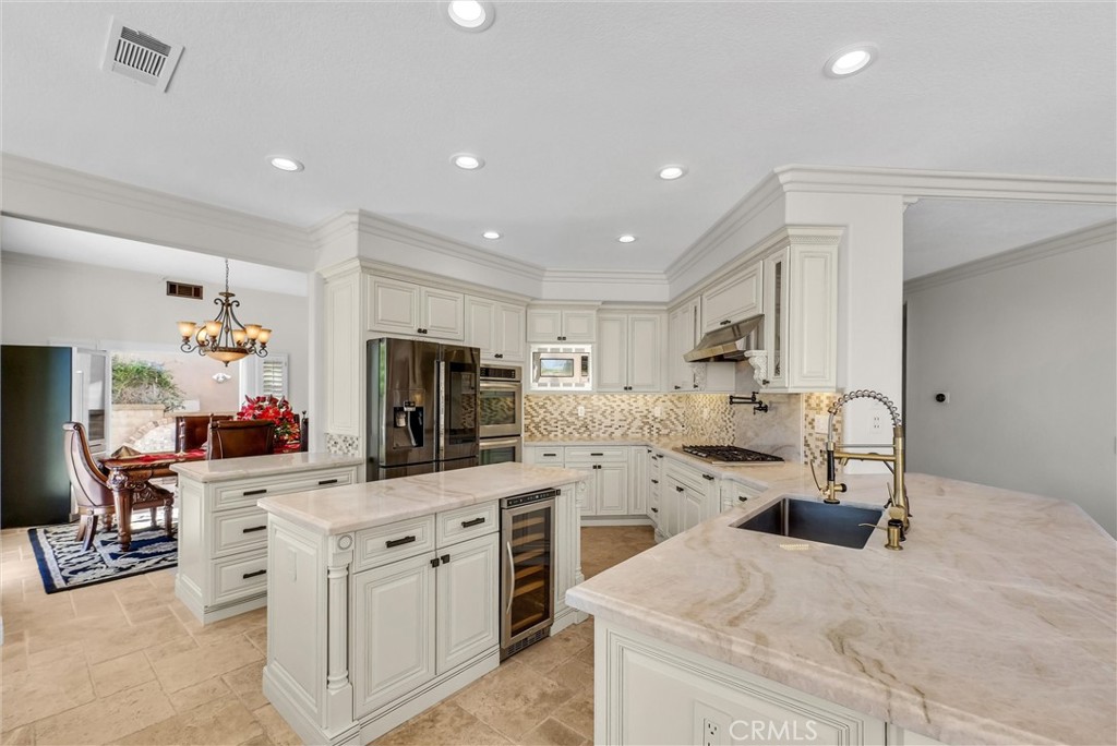 25672 Raintree Road Laguna Hills, CA 92653 - Photo 16 of 50 a kitchen with white cabinets and stainless steel appliances