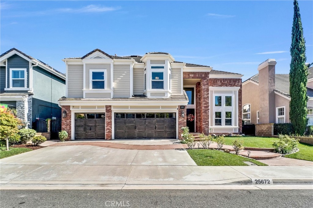 25672 Raintree Road Laguna Hills, CA 92653 - Photo 2 of 50 a view of a white house with a yard and large windows