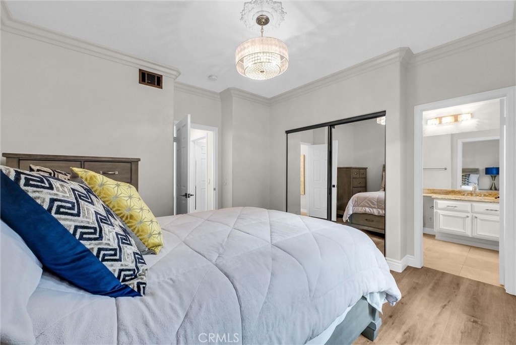 25672 Raintree Road Laguna Hills, CA 92653 - Photo 23 of 50 a bedroom with a large bed and a chandelier