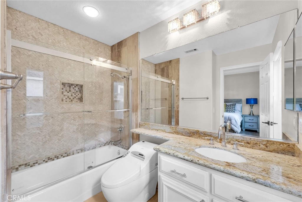 25672 Raintree Road Laguna Hills, CA 92653 - Photo 24 of 50 a bathroom with a granite countertop sink a toilet and shower