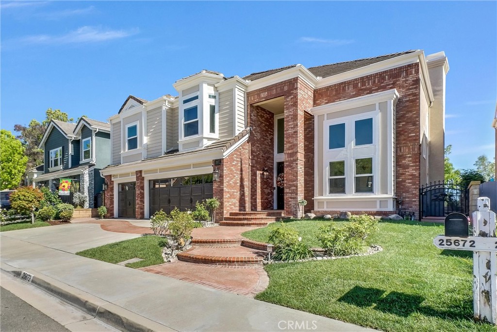 25672 Raintree Road Laguna Hills, CA 92653 - Photo 3 of 50 front view of a brick house with a yard