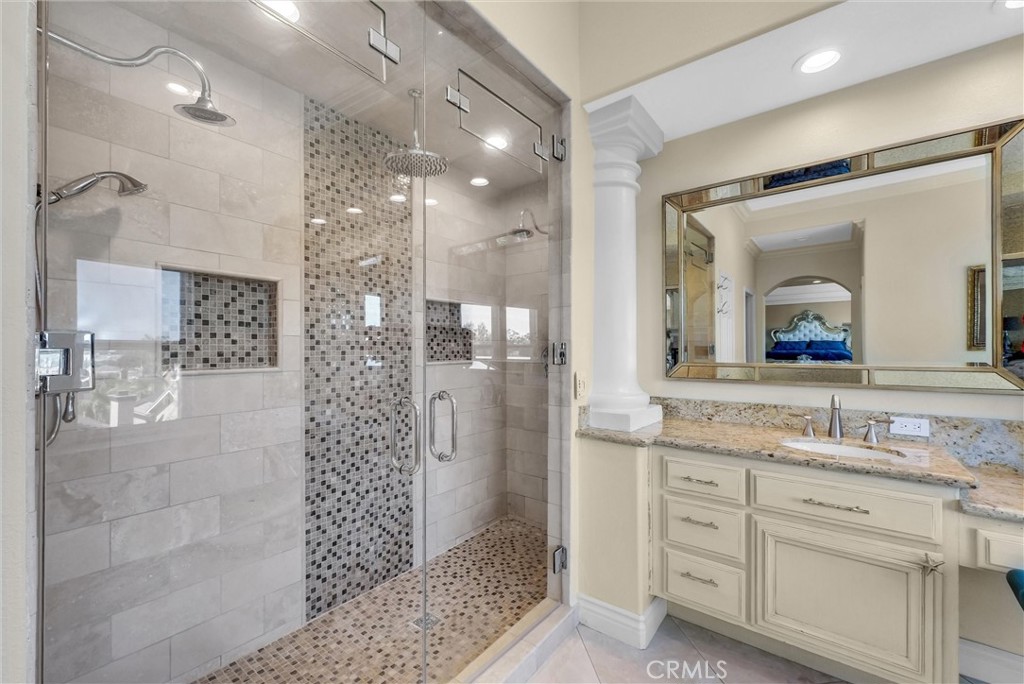 25672 Raintree Road Laguna Hills, CA 92653 - Photo 33 of 50 a bathroom with a granite countertop sink mirror and shower