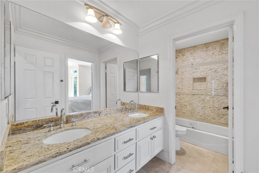 25672 Raintree Road Laguna Hills, CA 92653 - Photo 42 of 50 a bathroom with a granite countertop sink and a mirror