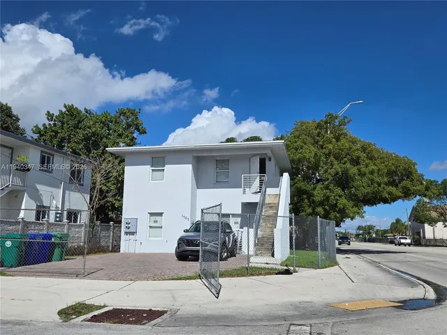 a view of a white house with a fountain in front of it