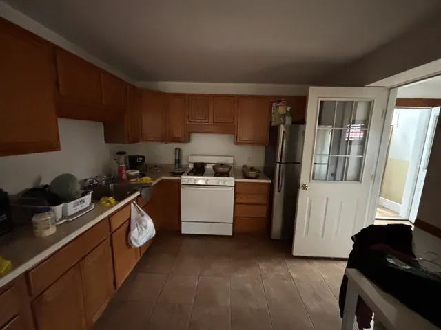 a kitchen with a refrigerator and a stove top oven