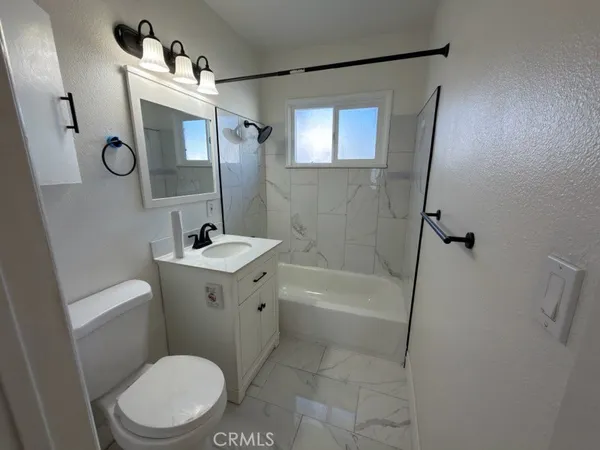 a white toilet sitting next to a bath tub