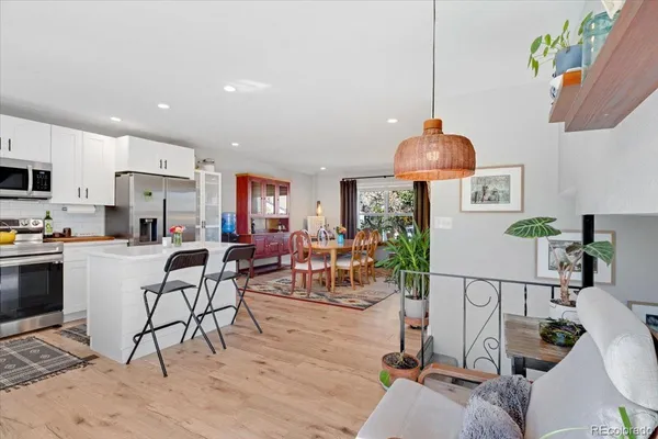 a living room with furniture a dining table and a potted plant