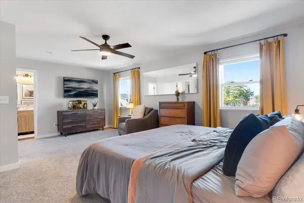 a bedroom with a bed a large mirror and a flat tv screen