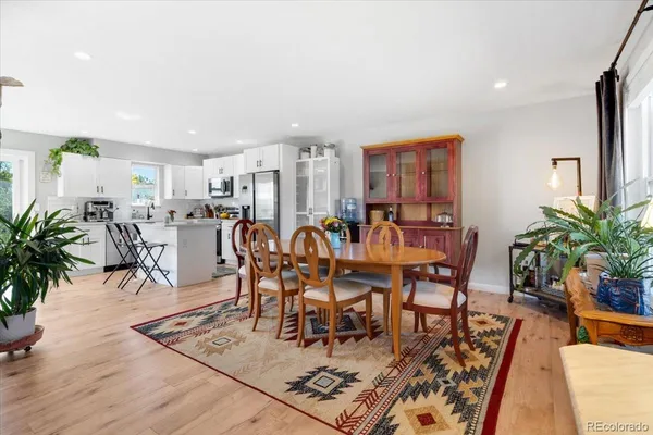 a dining room with furniture potted plants and wooden floor