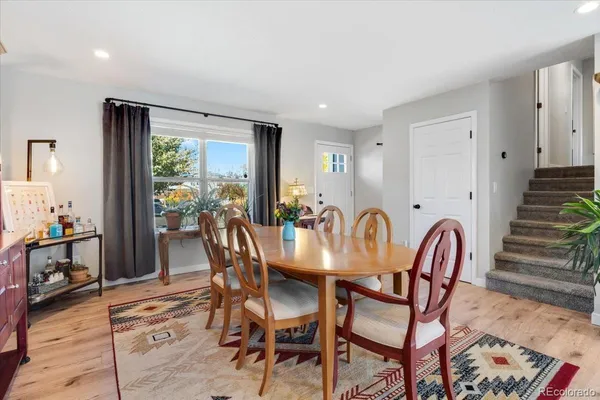 a view of a a dining room with furniture window and wooden floor