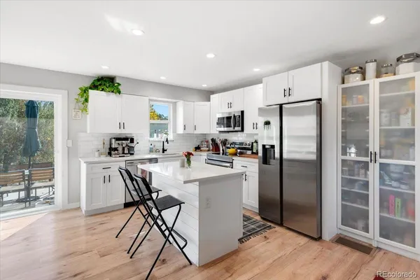 a kitchen with refrigerator a table and chairs