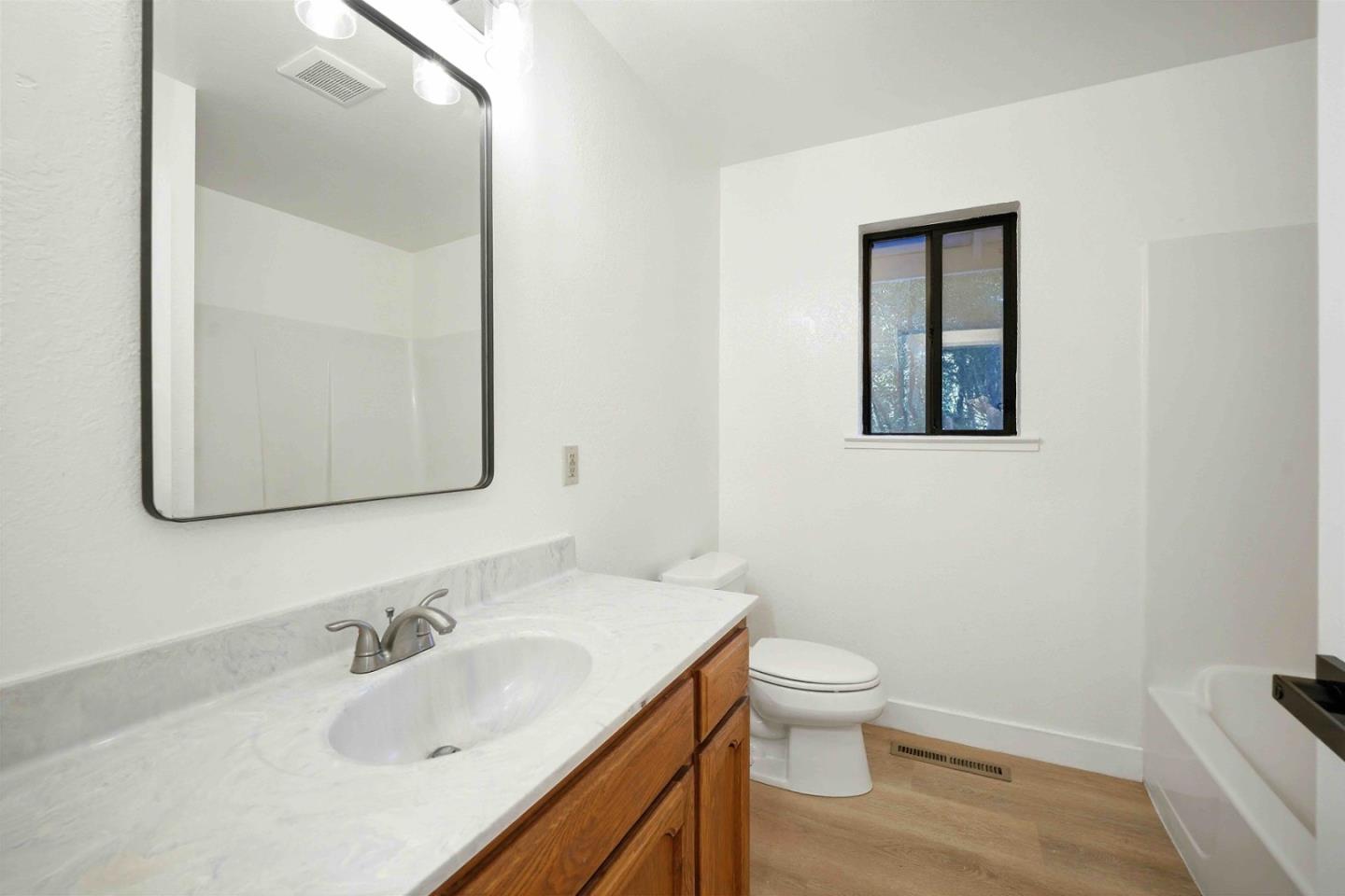 178 Madrona Road Boulder Creek, CA 95006 - Photo 13 of 22 a bathroom with a granite countertop sink toilet and mirror