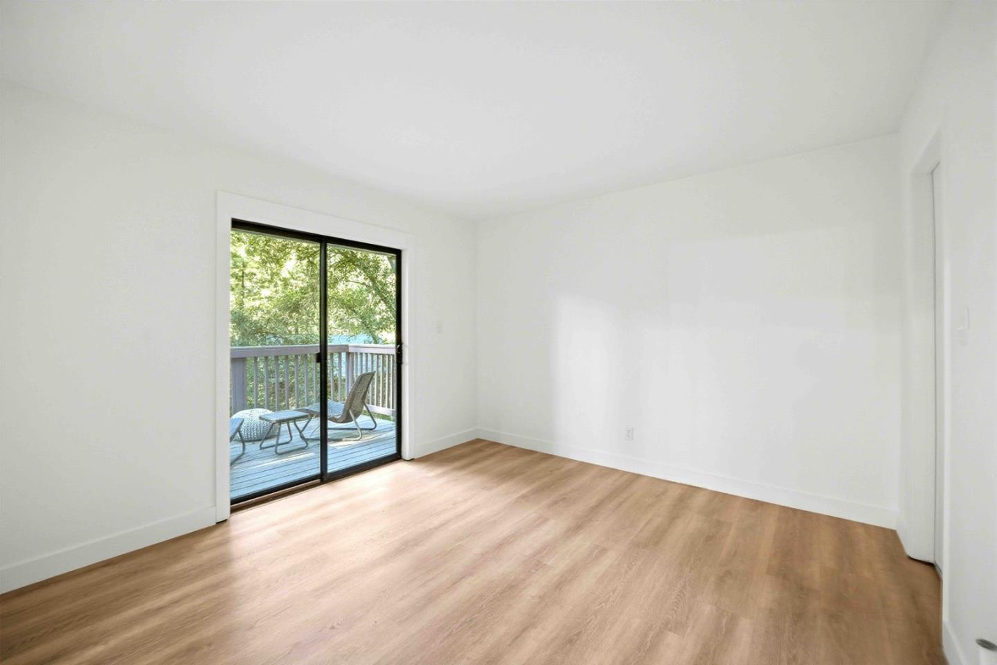 178 Madrona Road Boulder Creek, CA 95006 - Photo 17 of 22 an empty room with wooden floor and windows