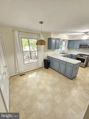 a kitchen with kitchen island a stove a sink and a refrigerator