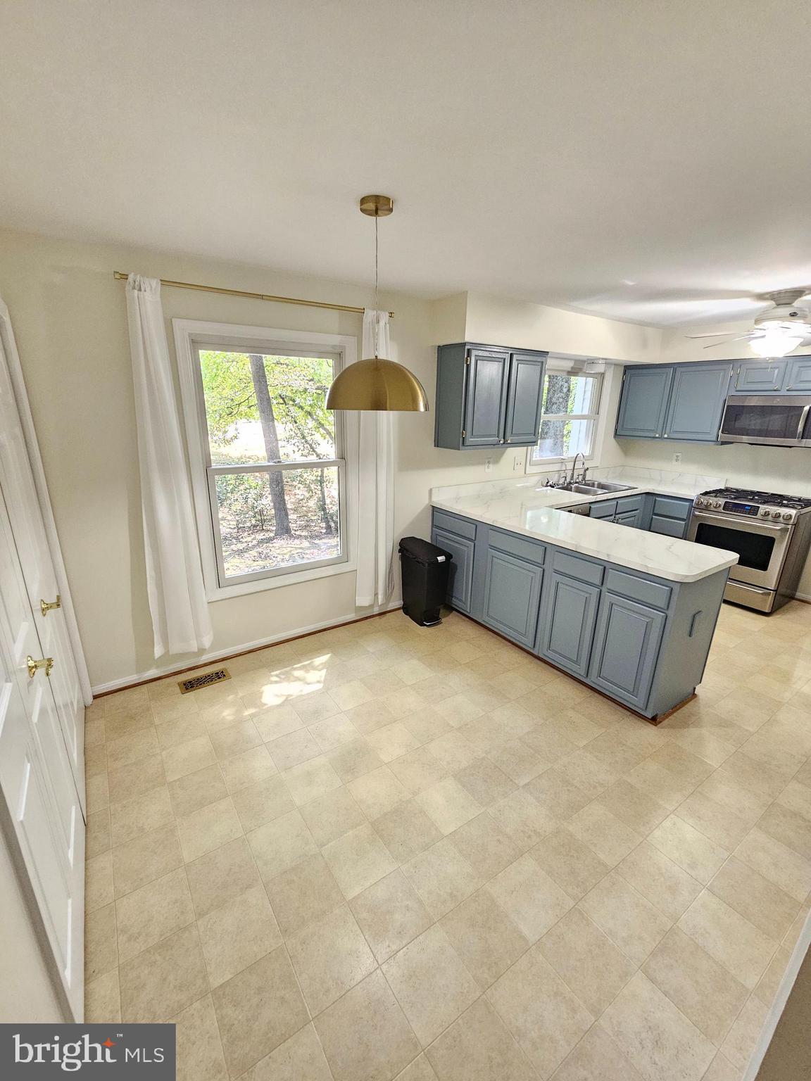 11321 Classical Lane Silver Spring, MD 20901 - Photo 12 of 66 a large kitchen with kitchen island granite countertop a sink cabinets and window