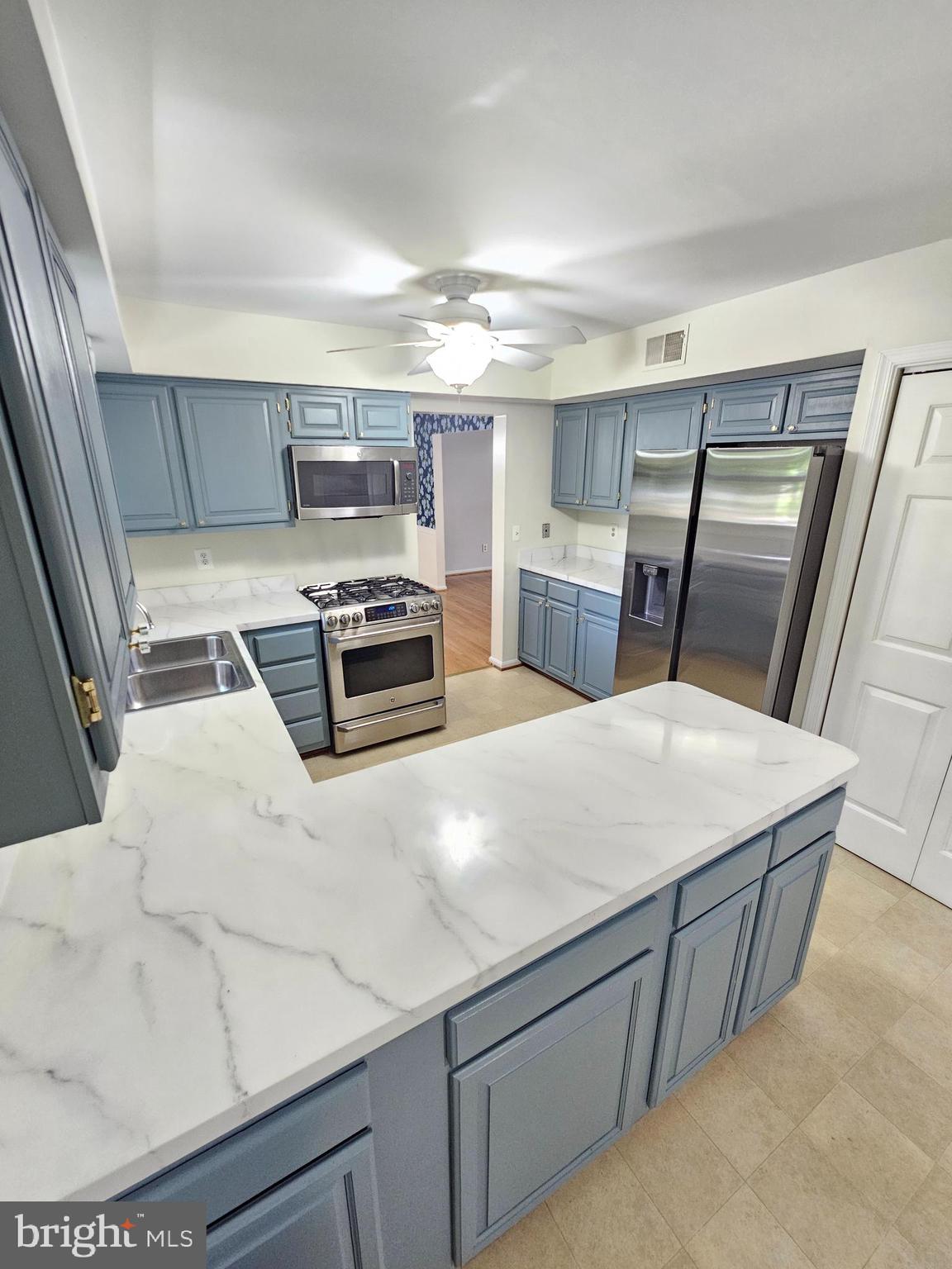 11321 Classical Lane Silver Spring, MD 20901 - Photo 16 of 66 a kitchen with kitchen island a stove a sink and a refrigerator