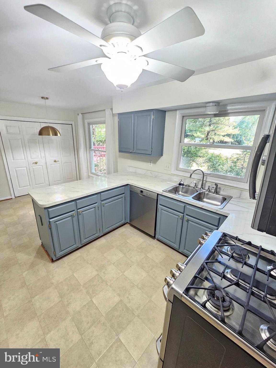 11321 Classical Lane Silver Spring, MD 20901 - Photo 17 of 66 a kitchen with stainless steel appliances a sink a stove a refrigerator cabinets and living room view