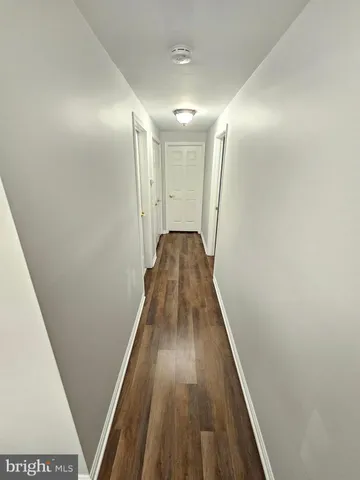 a view of walk in closet with wooden floor and stairs