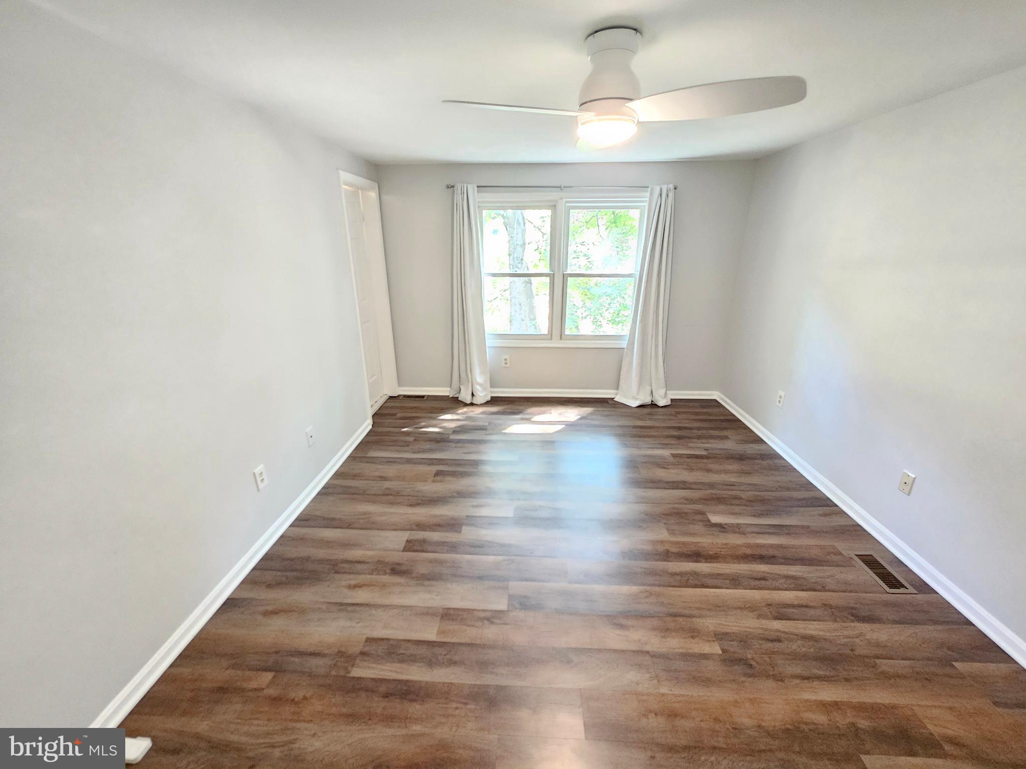 11321 Classical Lane Silver Spring, MD 20901 - Photo 43 of 66 a view of an empty room with wooden floor and a window